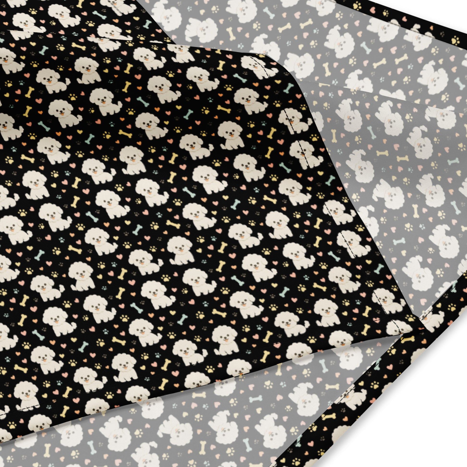 Close-up of black bandana fabric with cute Bichon Frise dog pattern, paw prints, hearts, and bones design