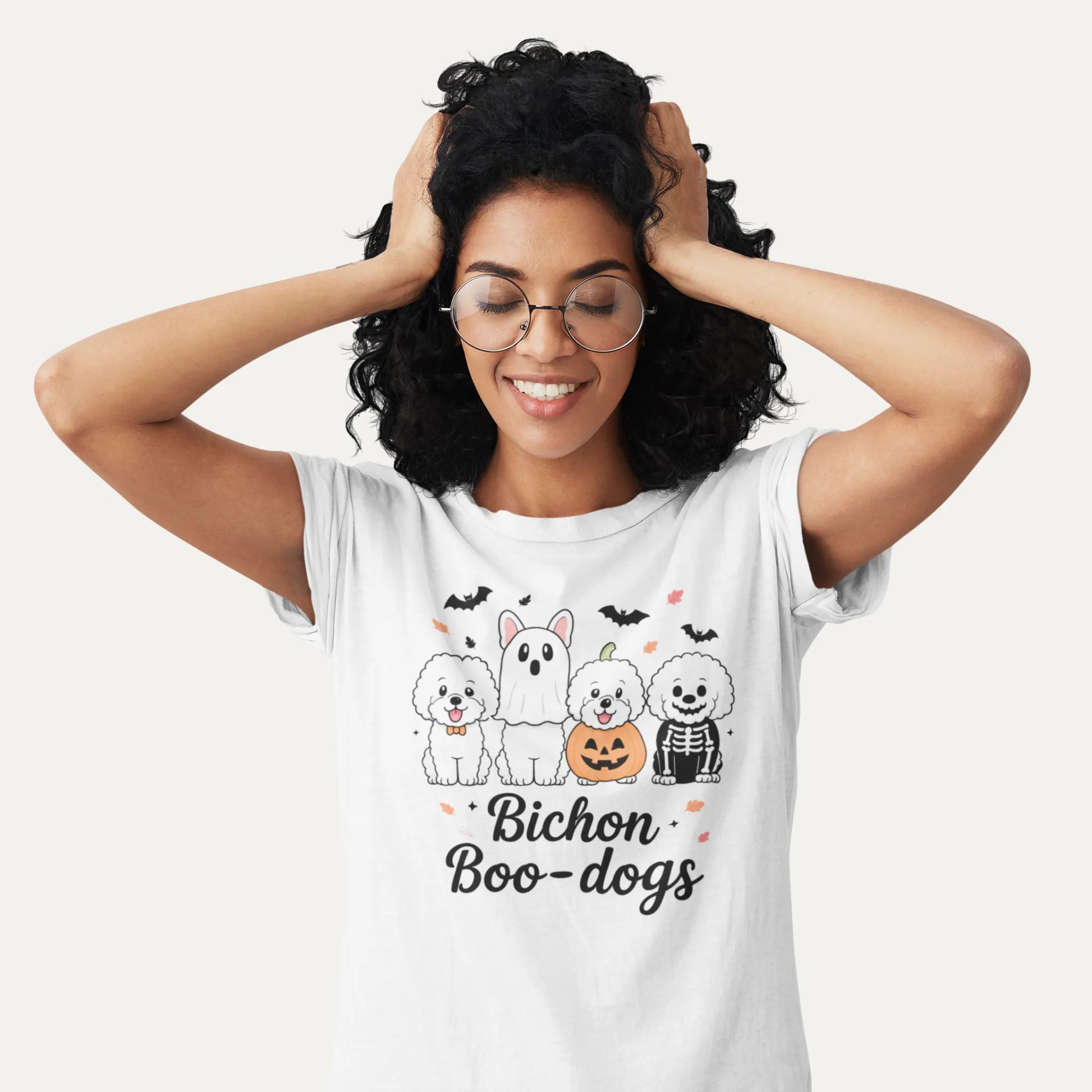 Smiling woman wearing a white Bichon Boo-dogs Halloween shirt with four cute Bichon Frise dogs in spooky costumes