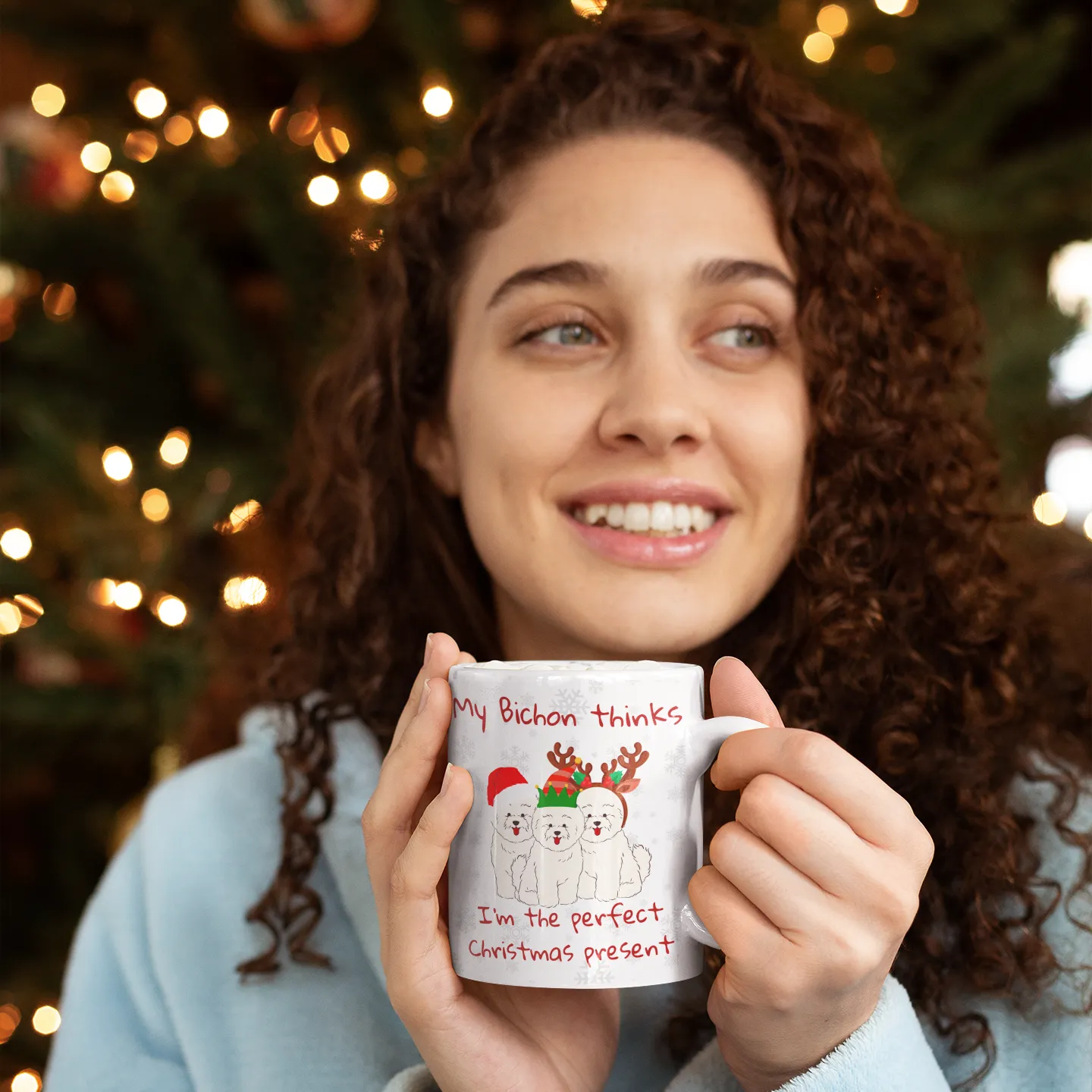 Woman holding a Bichon Frise Christmas mug with the text My Bichon thinks I'm the perfect Christmas present – cute holiday gift idea
