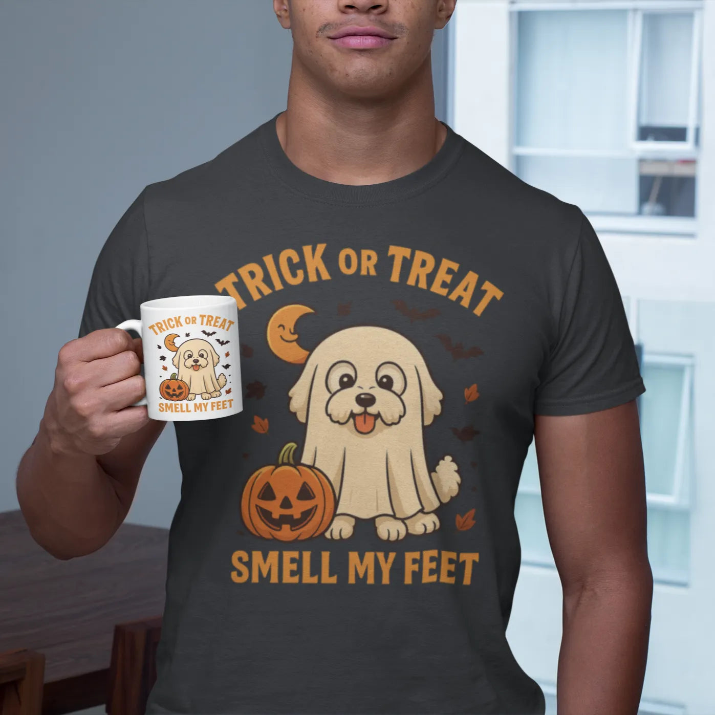 Man holding a white Halloween coffee mug and wearing a matching Trick or Treat Bichon Frise T-shirt with 'Smell My Feet' design