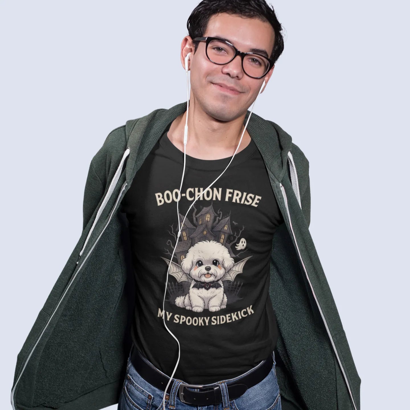 A mockup of a man wearing a black unisex t-shirt with a funny Halloween design for Bichon Frise dog lovers. The graphic features a cute Bichon Frise puppy with bat wings and the text "BOO-CHON FRISE MY SPOOKY SIDEKICK