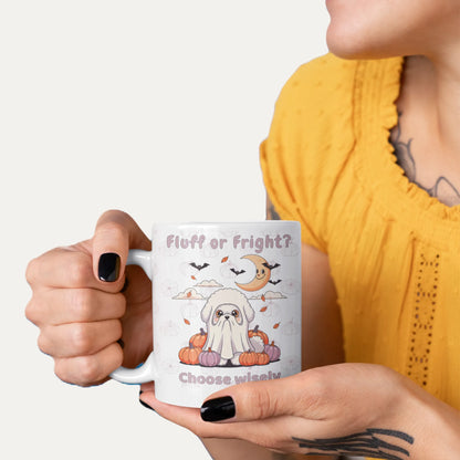 Smiling woman holding a white Halloween mug with a cute Bichon Frise ghost costume design and the text 'Fluff or Fright? Choose wisely'