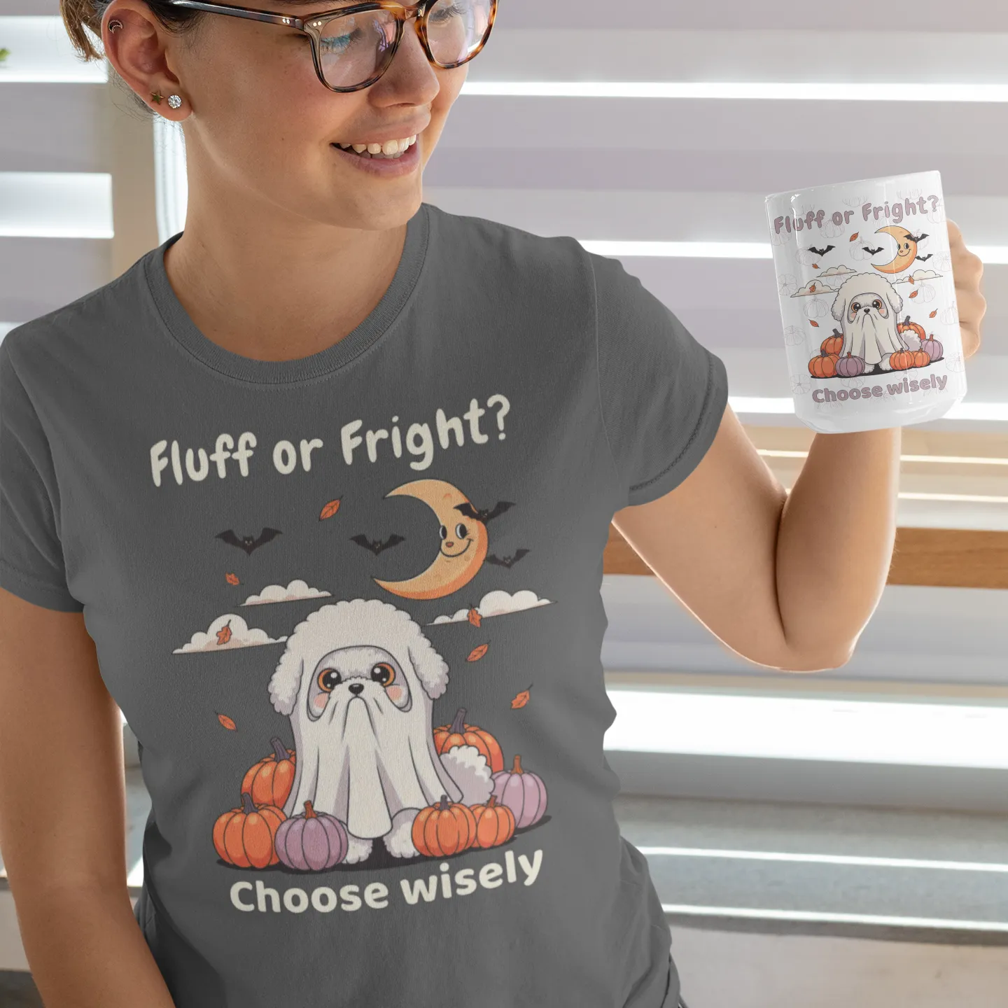 Smiling woman holding a Halloween mug and wearing a matching T-shirt with a cute Bichon Frise dressed as a ghost, surrounded by pumpkins and bats, next to the text "Fluff or Fright? Choose wisely".
