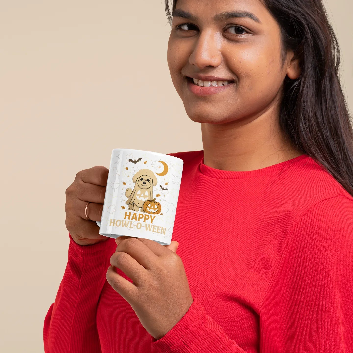 Smiling woman in red shirt holding a white Halloween mug with a cute Bichon Frise ghost design and the text 'Happy Howl-o-Ween