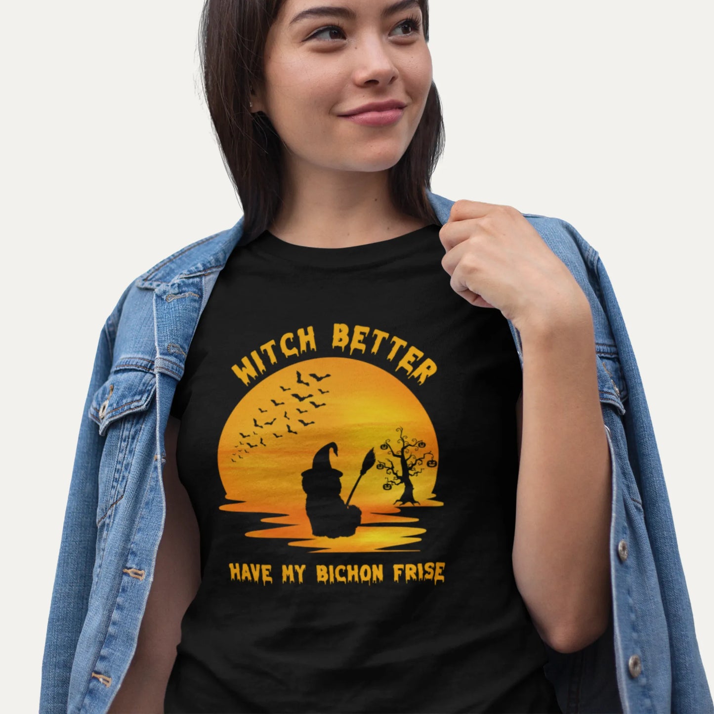 Person wearing a black t-shirt with a graphic and text, standing against a plain background