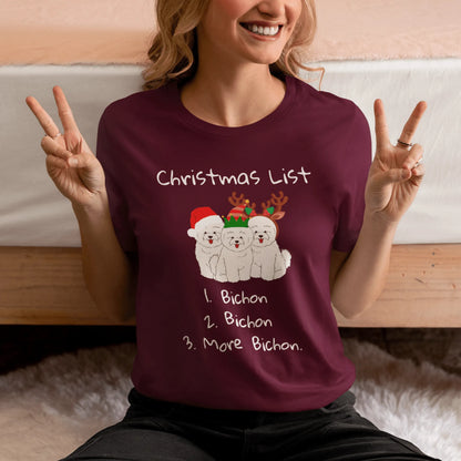 "Funny Christmas-themed unisex t-shirt with text 'Christmas List: 1. Bichon 2. Bichon 3. More Bichon' – perfect holiday gift for dog lovers, especially Bichon Frisé owners; cheerful and unique dog print shirt for men and women."