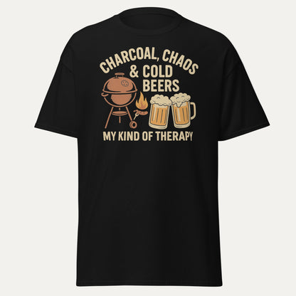 Retro-style graphic design featuring a BBQ grill, two cold beers, flames and the text "Charcoal, Chaos & Cold Beers – My Kind of Therapy" on a vintage Father's Day t-shirt.